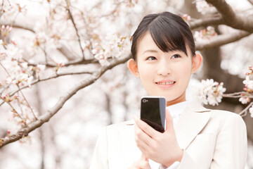 携帯電話を見るＯＬ