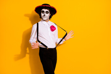 Photo of frightening zombie guy prepare latino dance spanish festival rumba wait partner wear white shirt rose death costume sombrero suspenders isolated yellow color background