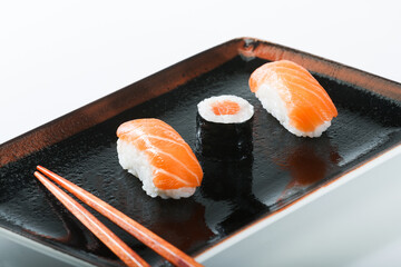 Traditional japanese nigiri and maki sushi on the plate, board and table.
