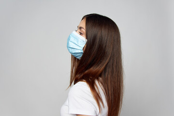 Girl in a medical mask on a white t-shirt face side view