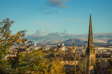 Fototapeta premium View Over Glasgow From Queens Park With Autumn Leaves and Snow on the Hills in the Background