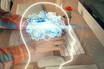 Man typing on keyboard background with brain hologram. Concept of big Data. Double exposure.