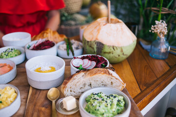 Cropped image of female sitting at cafeteria table with ordered healthy food for lunch with green guacamole and brusquet, tasty chia yogurt and beetroot salad for appetizer breakfast in restaurant