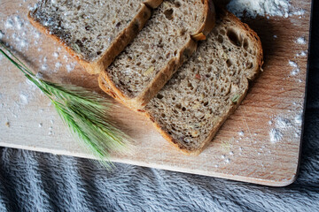 
Bread lies on a kitchen board and spikelets of wheat