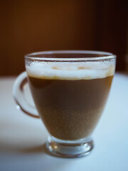 picture of a cup of coffe with milk into a white table