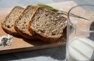 
Bread lies on a kitchen board and spikelets of wheat
