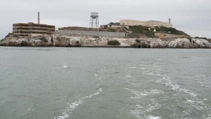 Fototapeta na wymiar Alcatraz island in San Francisco Bay, California USA. Federal prison for gangsters on rock, foggy weather. Historic jail, cliff in misty cloudy harbor. Gaol for punishment and imprisonment for crime