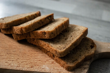 
Bread lies on a kitchen board and spikelets of wheat