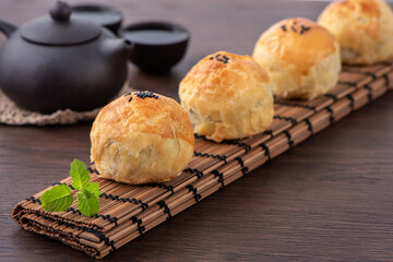 Moon cake yolk pastry, mooncake for Mid-Autumn Festival holiday, close up design concept on dark wooden table background