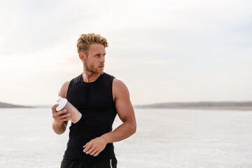 Image of young athletic sportsman drinking protein shake