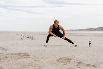 Image of young athletic sportsman doing exercise while working out