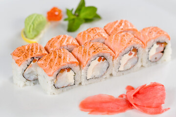 Суши красиво выложены дополнительными ингредиентами снятые на белом фоне