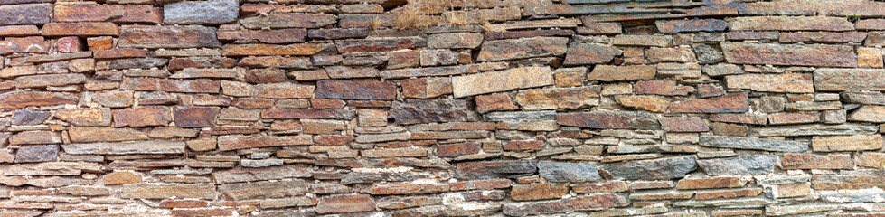 panorama of a wall made of flat old stone