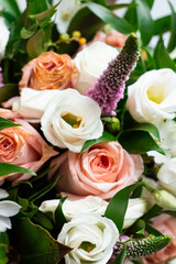 Delicate pink and white roses in green foliage. Bridal bouquet 