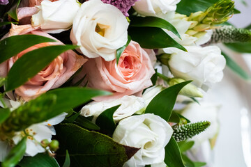 Delicate pink and white roses in green foliage. Bridal bouquet 