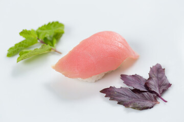 Суши красиво выложены дополнительными ингредиентами снятые на белом фоне