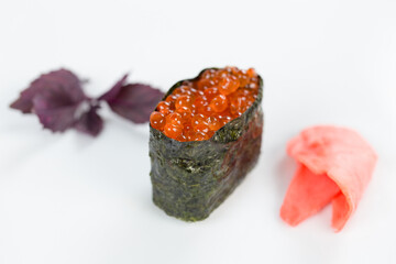 Суши красиво выложены дополнительными ингредиентами снятые на белом фоне