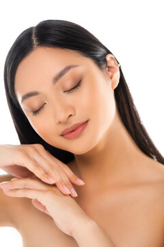 Portrait of young asian woman with closed eyes touching her hands isolated on white