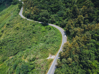 Road on the ridge A long road on a green mountain in asia
