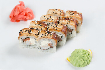 Суши красиво выложены дополнительными ингредиентами снятые на белом фоне