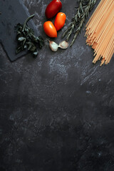 pasta garlic and parsley on black background