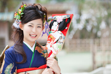 羽子板を持つ振袖姿の女性