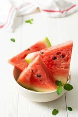 Juicy ripe sweet red watermelon slices with mint in a plate on a white background