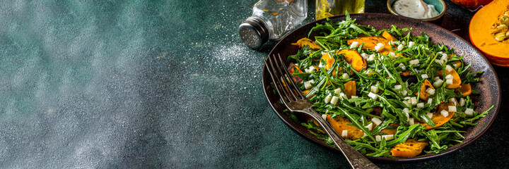 Homemade pumpkin salad with grilled pumpkin slices, arugula and cheese. Autumn pumpkin salad...
