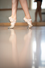 Legs and slippers of classical ballet dancers rehearsing
