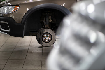 Obraz na płótnie Canvas Car mechanic changind tires of a car in a repair shop/car garage (shallow DOF/color toned image)