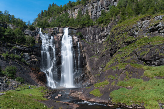 Skjervsfossen waterfall, on the road between Granvin and Voss, Hordaland, Norway. Impressive beautiful win falls plunging 150 metres in a narrow canyon