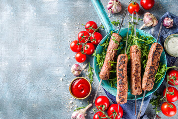 Shish kebab on skewers, from minced beef meat. Lula kebab, traditional Caucasian recipe. On blue...