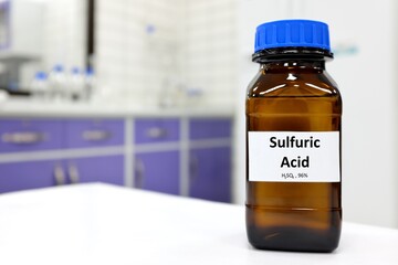Selective focus of strong sulfuric acid chemical in brown amber glass bottle inside a laboratory...