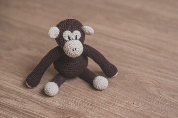 handcrafted crochet amigurumi monkey in wooden background © Rick
