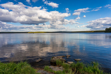 A picturesque landscape with a lake and beautiful clouds in the sky. Ural landscape of nature.