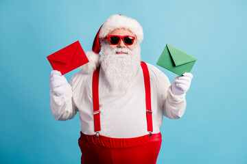 Portrait of his he nice attractive cheerful confident thick white-haired Santa father holding in hands colorful envelopes season sale offer isolated bright vivid shine vibrant blue color background
