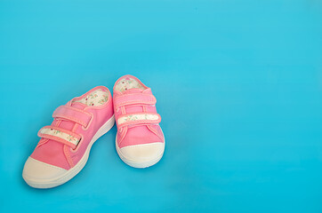 pink baby sneakers on a blue background 