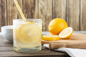Brazilian sicilian lemon caipirinha in a glass with ice with fruit slices over wooden board