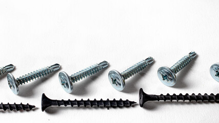 Self-cutters on a white background banner with space for text. Construction tools, self-tapping screws for fastening. Black screw hardware.