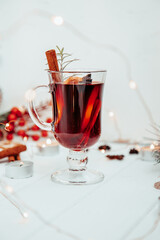  a glass of hot mulled wine with rosemary on a white plate in a New Year's atmosphere