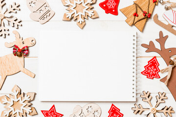 Top view of notebook on wooden background made of Christmas decorations. New Year concept