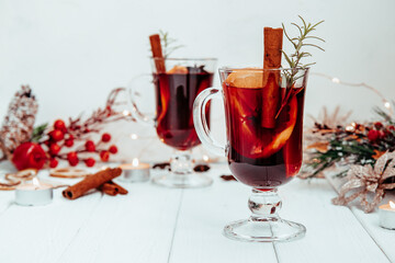  hot homemade mulled wine with rosemary on a white plate in a New Year's atmosphere.