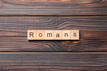 romans word written on wood block. romans text on table, concept