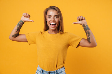 Happy young girl pointing fingers at blank t-shirt