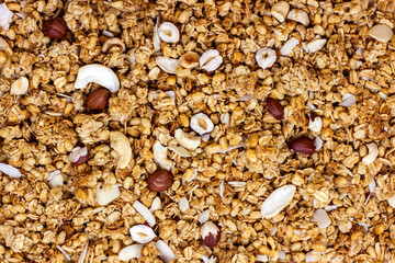 Brown homemade baking cereal granola with nuts for breakfast texture as a food background.