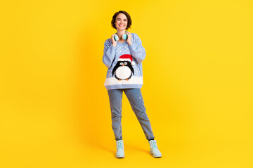 Fototapeta na wymiar Full body photo of attractive pretty lady listen cool earphones newyear celebration mood toothy smile wear ugly ornament sweater pullover jeans shoes isolated yellow bright color background