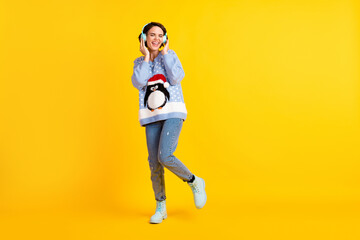 Full body photo of attractive lady youth student party newyear listen cool modern technology earphones radio wear ugly ornament sweater pullover jeans boots isolated yellow color background