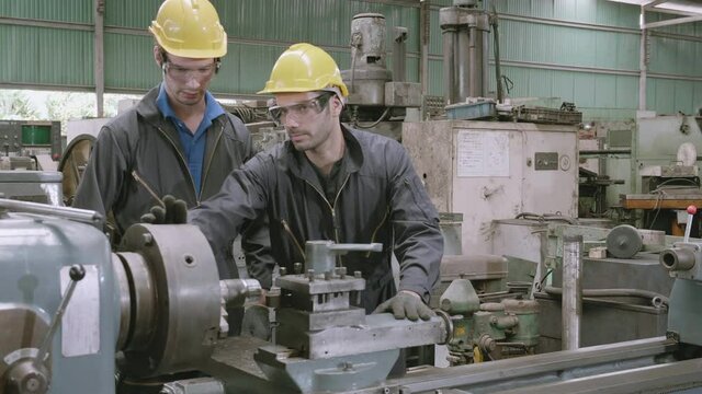 Engineer man training with foreman for apprentice using lathe, apprenticeship teaching with worker, technician and learning, inspector and labor, internship and workshop, industrial concept.
