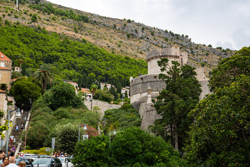 Torre de defensa de murallas entre arboles y turistas