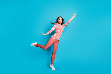 Fototapeta na wymiar Full length photo of excited energetic girl hold hand try catch dream parasol her hairstyle wind air blow wear good look casual outfit sneakers isolated over blue color background